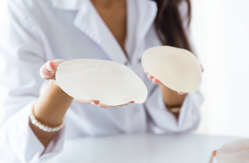 Female doctor choosing mammary prosthesis in the office. Portrait of female doctor choosing mammary prosthesis in the office.